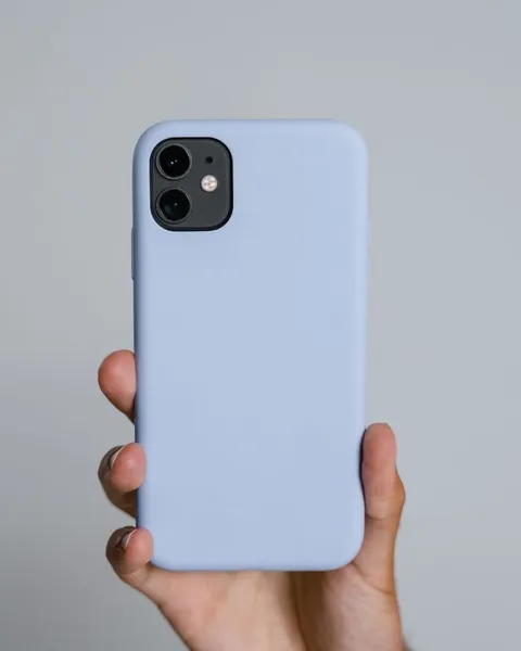 Hand hält ein Smartphone in einer hellblauen Silikonhülle