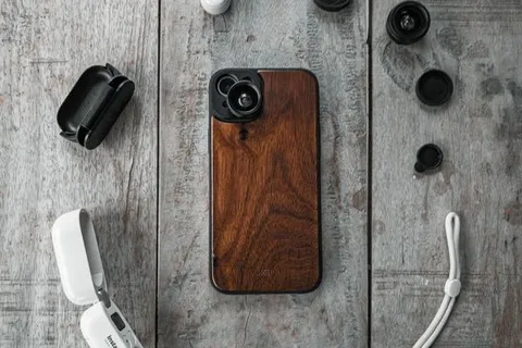 Smartphone mit Holzhülle und Zubehör als Flat-Lay